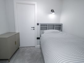 A bedroom featuring a bed and a cabinet at Frongoch Old Power House in Dolgellau