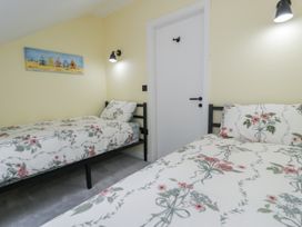 A bedroom with two beds and a door at Frongoch Old Power House Dolgellau