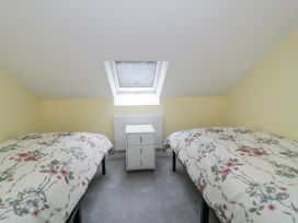 A bedroom with two beds and a nightstand at Frongoch Old Power House in Dolgellau