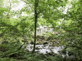 A house surrounded by trees and a stream at Frongoch Old Power House in Dolgellau