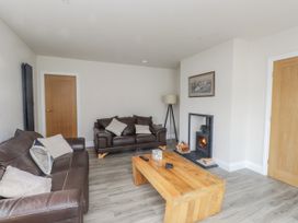 A living room with a sofa and fireplace at Morannedd in Morfa Nefyn