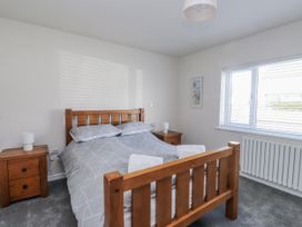 A bedroom with a wooden bed and bedside tables at Morannedd in Morfa Nefyn
