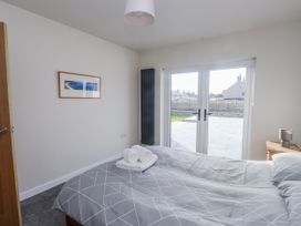 A bedroom with a bed and sliding doors at Morannedd Morfa Nefyn