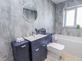 A bathroom with a sink, toilet, and bath tub at Morannedd in Morfa Nefyn