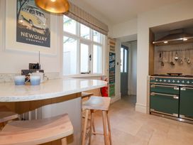 A kitchen with a green oven and bar stools at Beach View House in Newquay