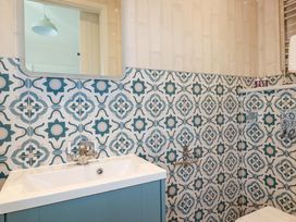 A bathroom with patterned wall tiles and a sink at Beach View House in Newquay