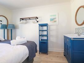 A bedroom with a bed and blue furniture at Beach View House in Newquay