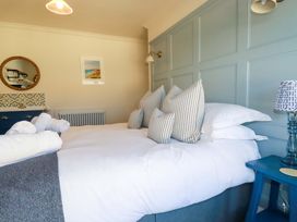 A bedroom with a bed and decorative pillows at Beach View House in Newquay