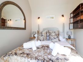 A bedroom with a bed, mirror, and shelves at Beach View House in Newquay