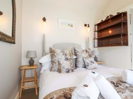 A bedroom with a bed, bedside tables and decorative items at Beach View House, Newquay