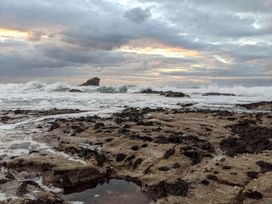 A rocky beach with waves and seaweed at Fairwinds Portreath