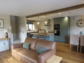 A living room with kitchen area featuring furniture and appliances at The Cartshed in Defford