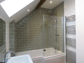 A bathroom with a shower over a bathtub at The Cartshed in Defford