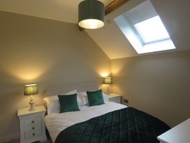 A bedroom with a bed and bedside tables at The Cartshed in Defford