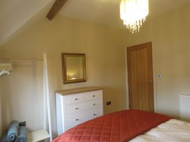 A bedroom with a bed and dresser at The Cartshed in Defford