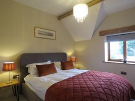 A bedroom featuring a bed, nightstand, and window at The Cartshed in Defford