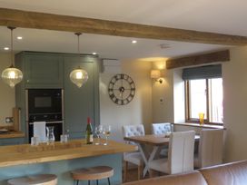 A kitchen with a table, chairs, and bar stools at The Cartshed in Defford
