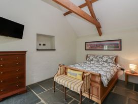 A bedroom with a bed, dresser and tv at St Dogwells Barn near Wolfscastle
