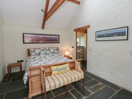 A bedroom with a bed and a bench at St Dogwells Barn near Wolfscastle