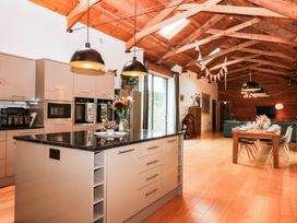 A kitchen with an island and seating at Halshanger Barn in Newton Abbot