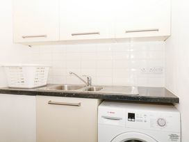 A laundry room with a washing machine and sink at Halshanger Barn in Newton Abbot