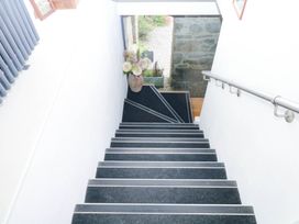 A staircase leading to a door with a flower arrangement at Halshanger Barn Newton Abbot