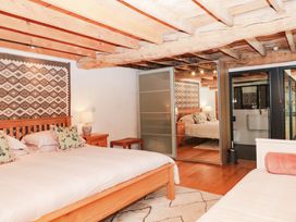 A bedroom with two beds and a bathroom at Halshanger Barn Newton Abbot
