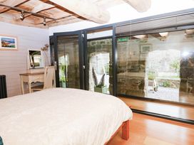 A bedroom with furniture and views to an outdoor area at Halshanger Barn in Newton Abbot