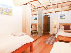 A bedroom with two beds and a mirror at Halshanger Barn in Newton Abbot