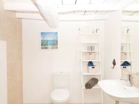 A bathroom featuring a toilet, sink, and storage shelf at Halshanger Barn Newton Abbot