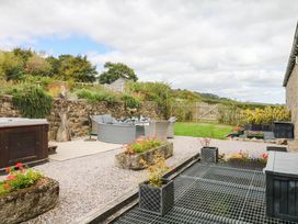 A garden with seating area and flower pots at Halshanger Barn in Newton Abbot