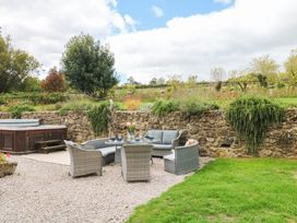 A garden with outdoor seating and a hot tub at Halshanger Barn Newton Abbot