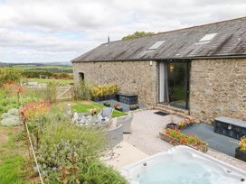 A garden with a hot tub and seating at Halshanger Barn in Newton Abbot