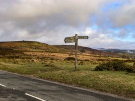 A road with a signpost indicating directions to Dartmeet, Two Bridges, Princetown, and Ashburton