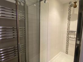 A bathroom with a shower and towel rack at Halshanger Barn near Ashburton