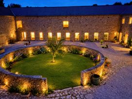 A courtyard with a tree and plants at Halshanger Barn near Ashburton