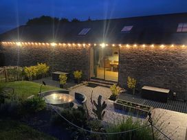 A garden with plants and seating at Halshanger Barn near Ashburton