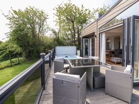 An outdoor patio with seating and a hot tub at The Lodge @ Racecourse House in Babell near Holywell