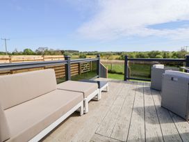 An outdoor seating area with a sofa on a deck at The Lodge @ Racecourse House Babell near Holywell