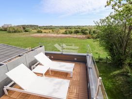 An outdoor terrace with lounge chairs at The Lodge @ Racecourse House in Babell near Holywell