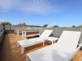 A roof terrace with sun loungers and an outdoor sofa at The Lodge @ Racecourse House in Babell near Holywell