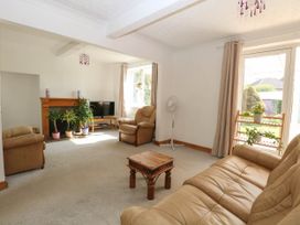 A living room with beige leather sofas wooden coffee table TV and houseplants at Cedar View in Hainford near Coltishall