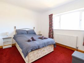 A bedroom with a double bed and bedside tables with lamps at Cedar View in Hainford near Coltishall