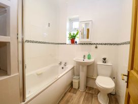 A bathroom with a bathtub a sink a toilet a small window and a plant at Cedar View in Hainford near Coltishall