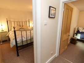 A view of two bedrooms with beds and bedside tables separated by a hallway at Seahaven in Allonby