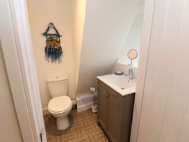 A small bathroom with a toilet and a sink cabinet with a mirror on the sink at Seahaven in Allonby