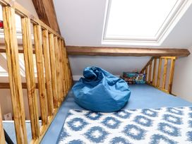 A loft space with a blue bean bag and board games near a skylight window at Seahaven in Allonby
