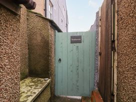 A narrow outdoor passage with textured walls and a blue wooden gate with a Seahaven sign