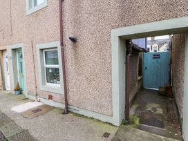 A narrow alley with a blue gate labeled Seahaven between buildings at Seahaven in Allonby