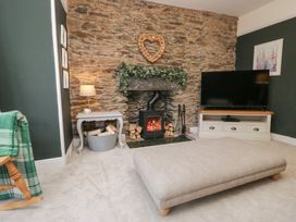 A living room with a stone wall and fireplace at The Wonky Nest in Bowness-On-Windermere